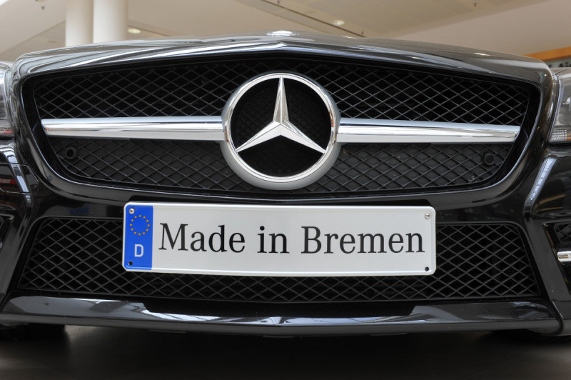 Der Kühlergrill eines Mercedes mit dem Mercedesstern. Auf dem Nummernschild steht "Made in Bremen"